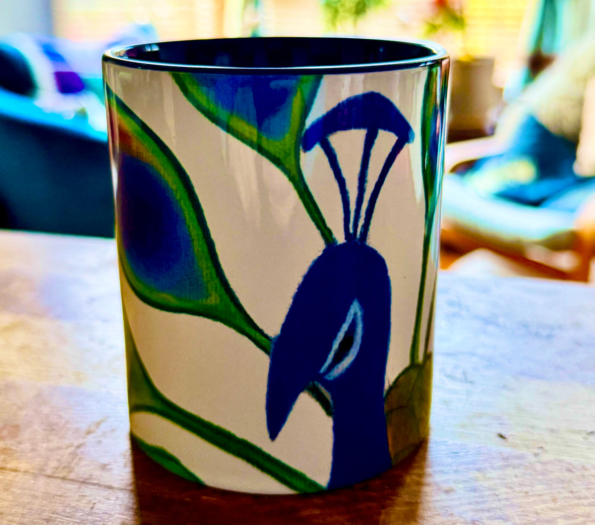 Sassy peacock coffee mug with deep blue handle and interior